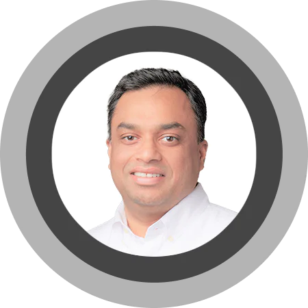 Smiling man with short black hair wearing a white shirt against a white background.