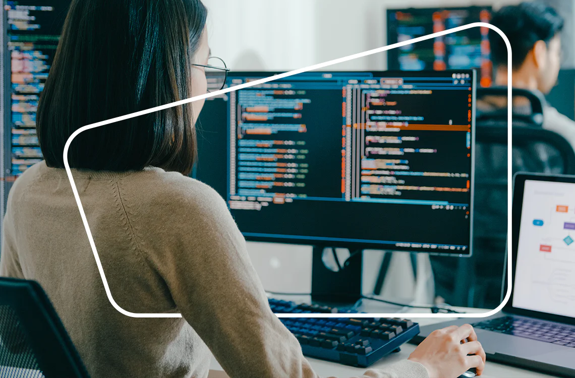 Woman coding on a computer screen in a modern office environment Woman coding on a computer screen in a modern office environment