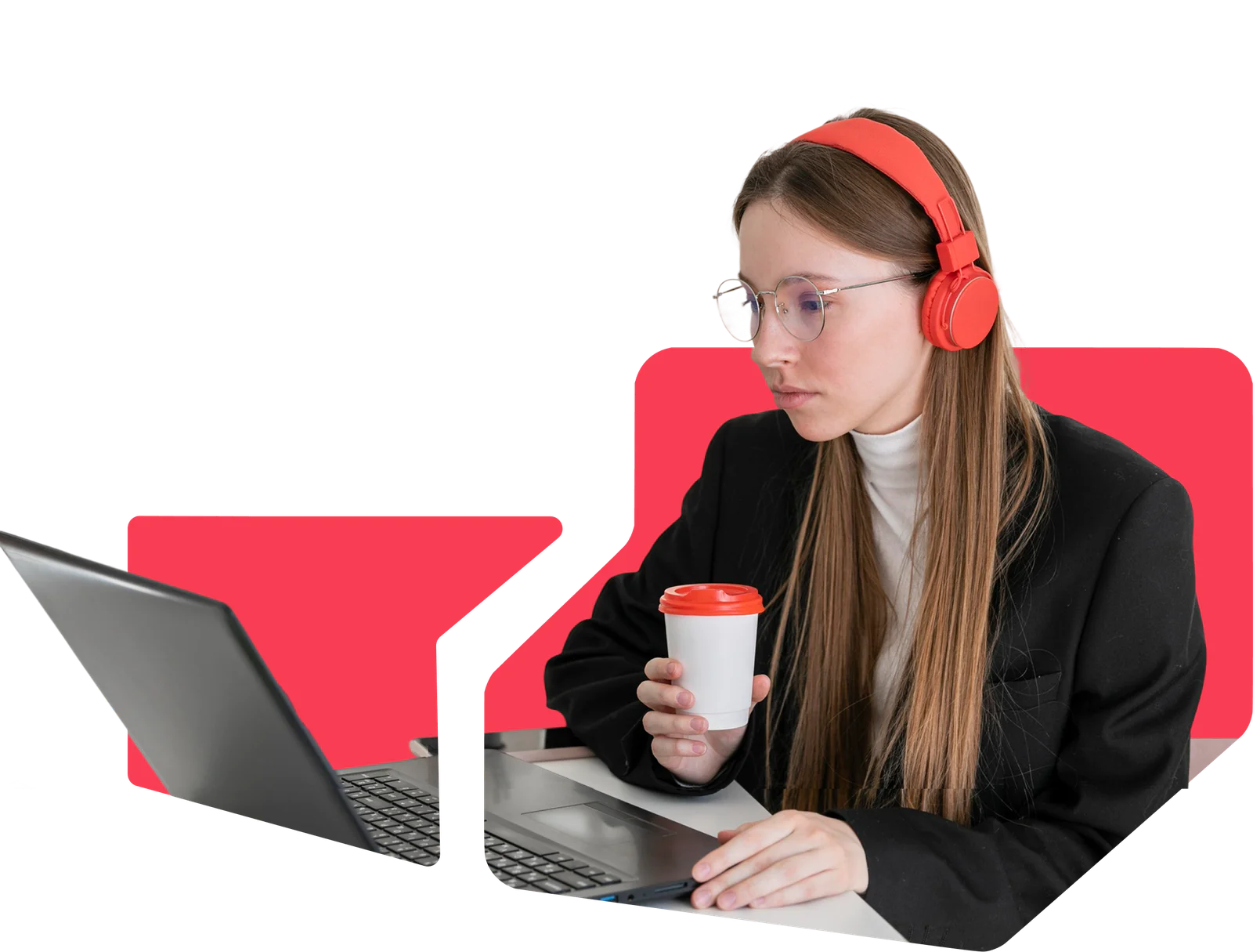 Woman in headphones working on a laptop and holding a coffee cup