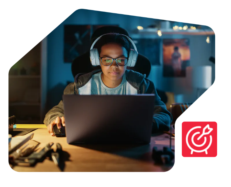 Person wearing headphones and glasses working on a laptop in a dimly lit room at night Person wearing headphones and glasses working on a laptop in a dimly lit room at night
