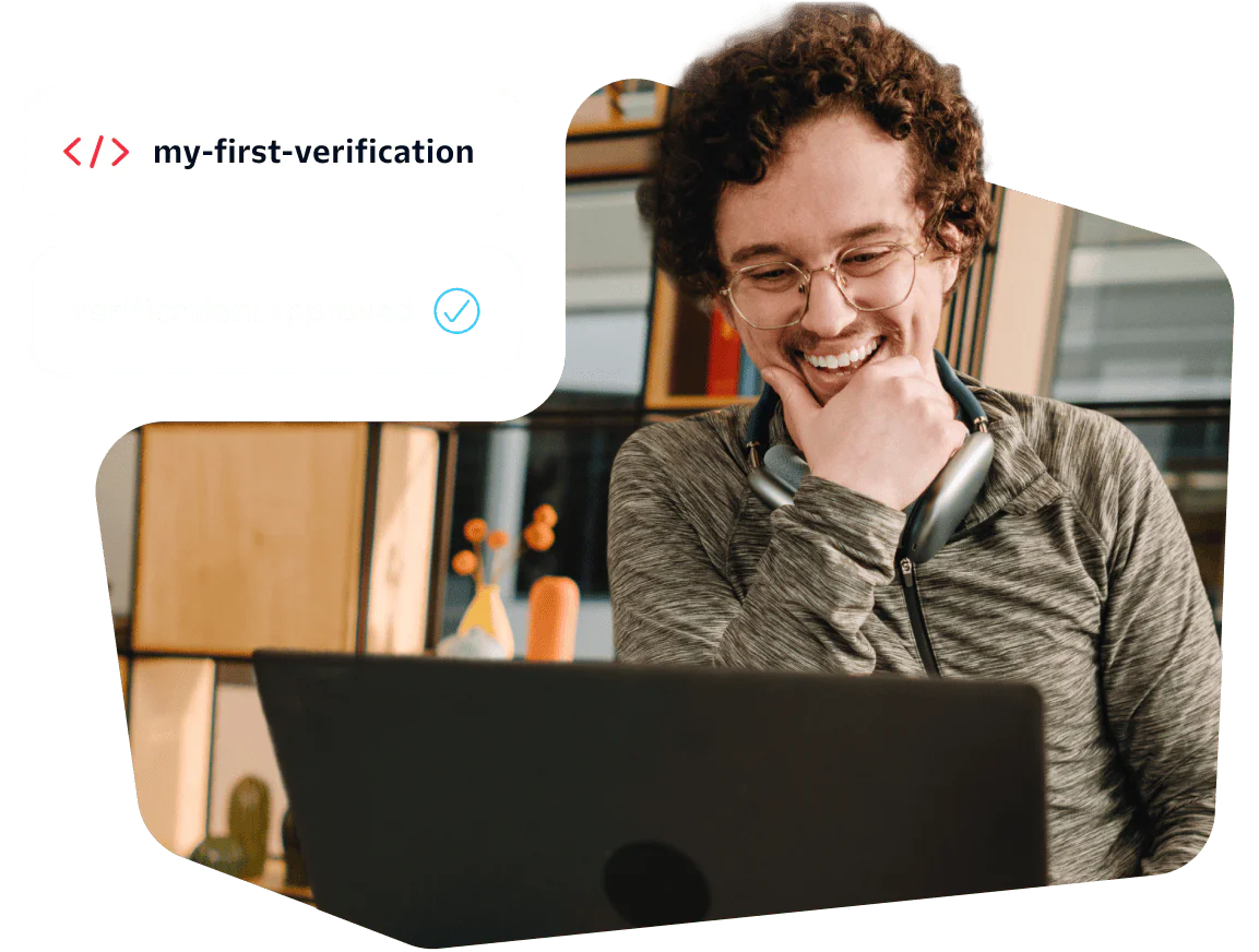 A smiling person wearing headphones looks at a laptop screen with a verification approval shown beside them.
